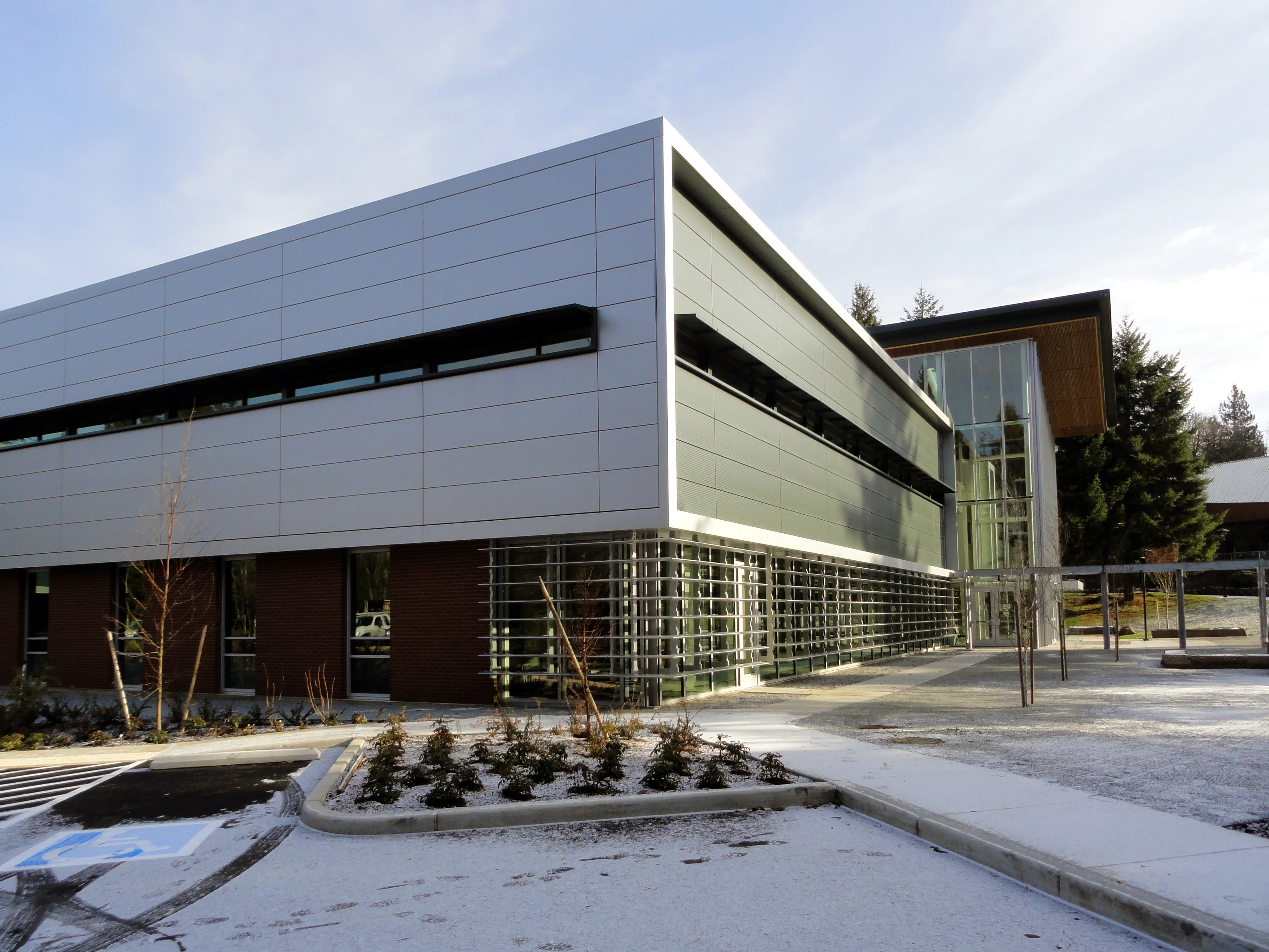 Photo taken from the South-West exterior of the building featuring shade-louvers at the exterior of the Library storefront windows.