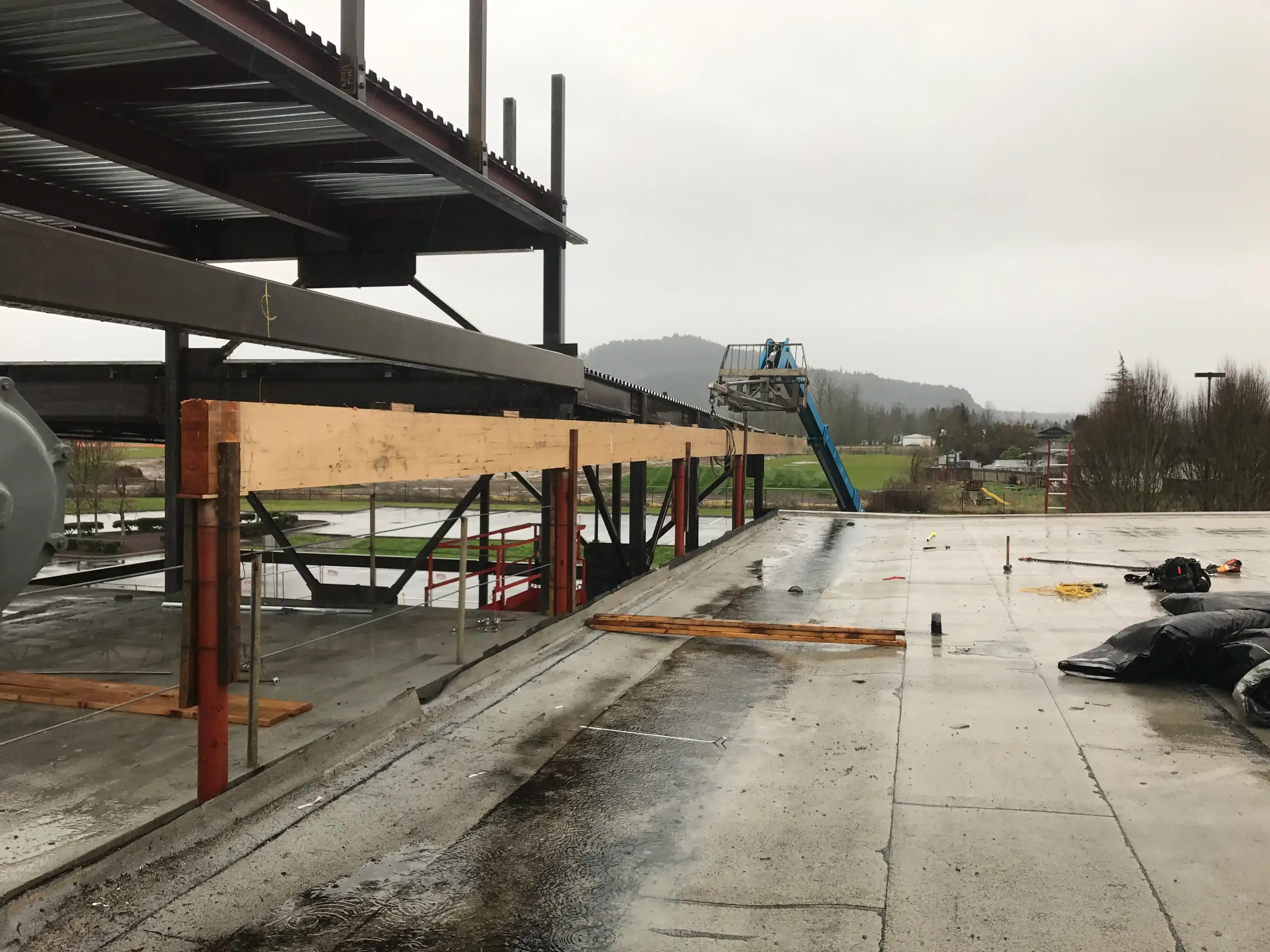 Setting a large beam on some columns at the roof level of the existing building.