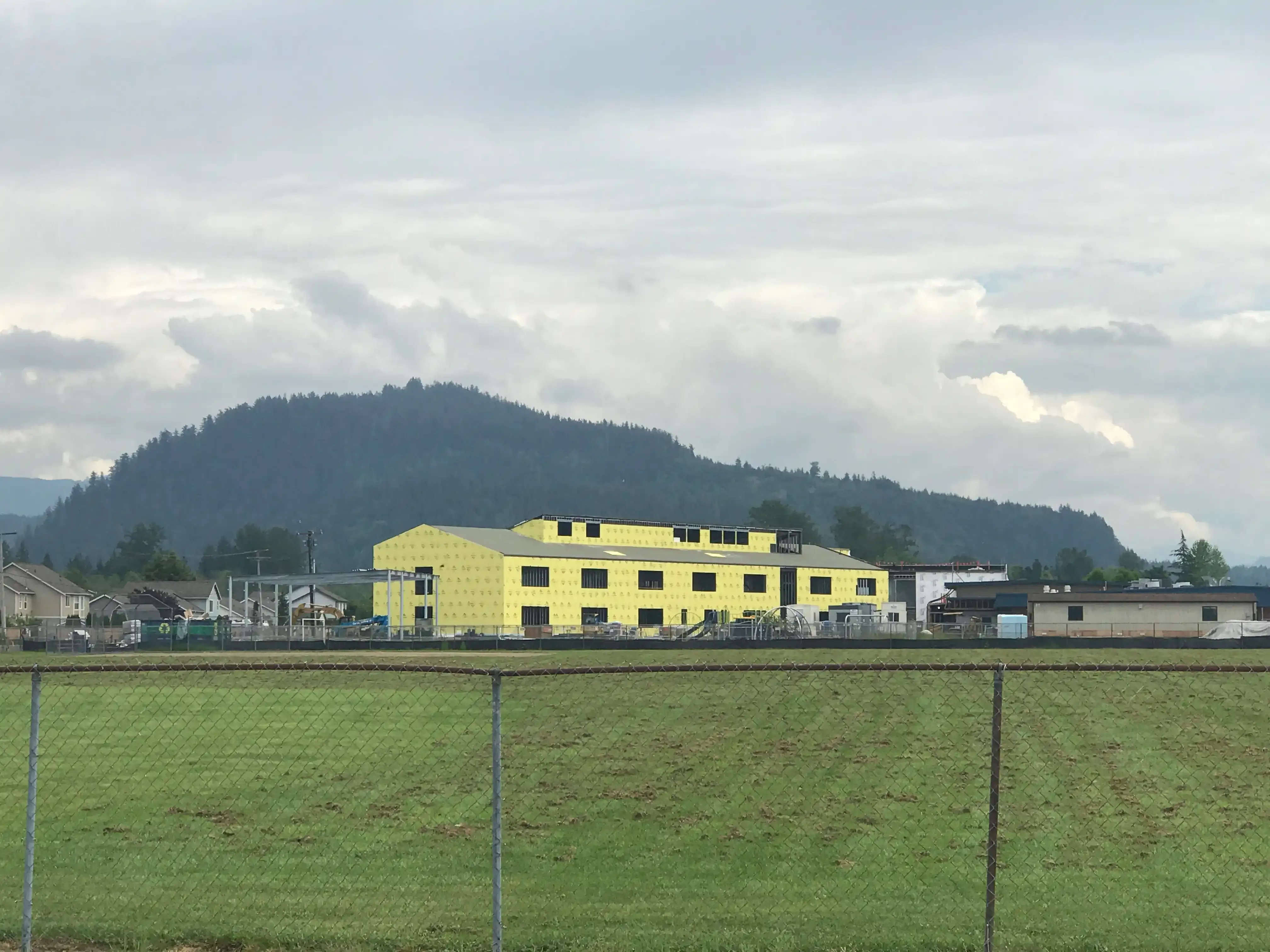 Photo of the building shell of 'B-wing' from across the large playfield of the school. Photo of the building shell of 'B-wing' from across the large playfield of the school.