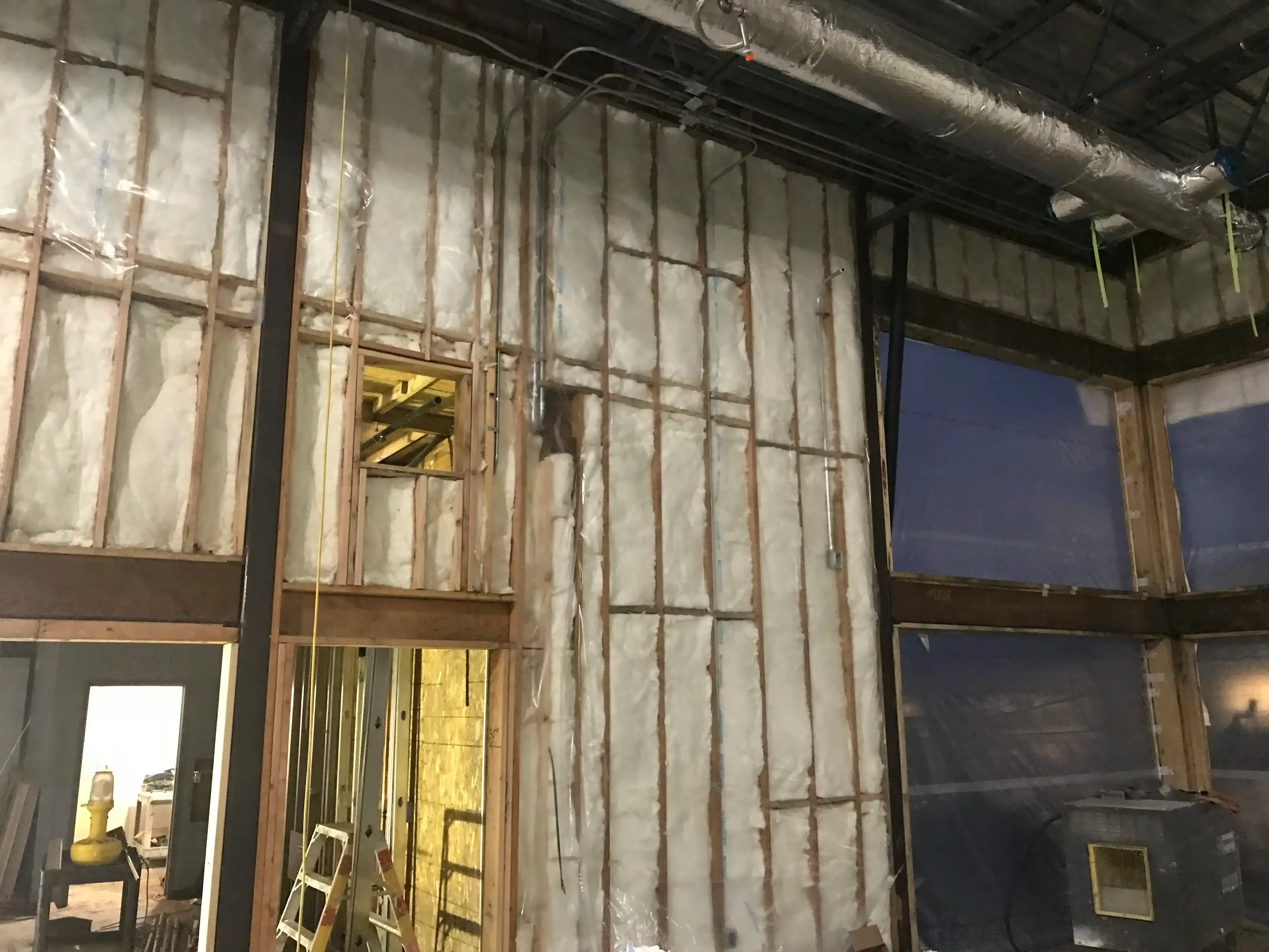 Photo of insulation and rough-in work getting compelted inside the new 'commons' space. Photo of insulation and rough-in work getting compelted inside the new 'commons' space.