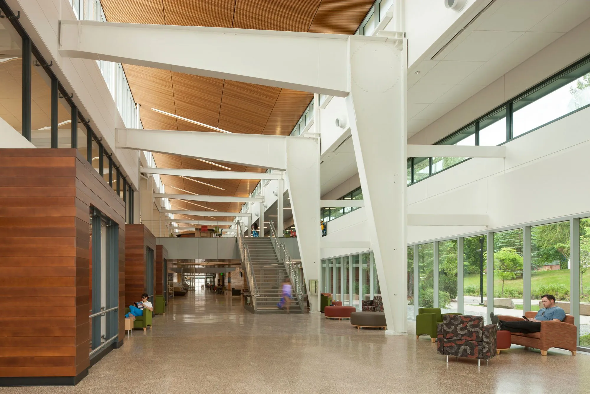 Photo taken from the ground floor looking down the length of the hall with the vaulted wood ceilings of the atrium above.