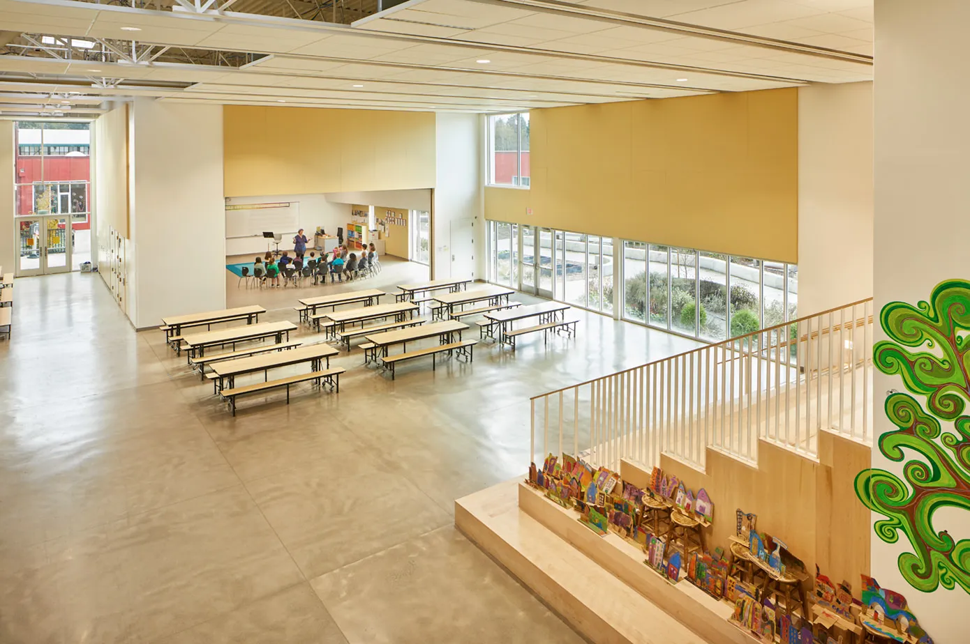 Photo of one of the commons spaces with an open partition wall exposing a music room. Photo of one of the commons spaces with an open partition wall exposing a music room.