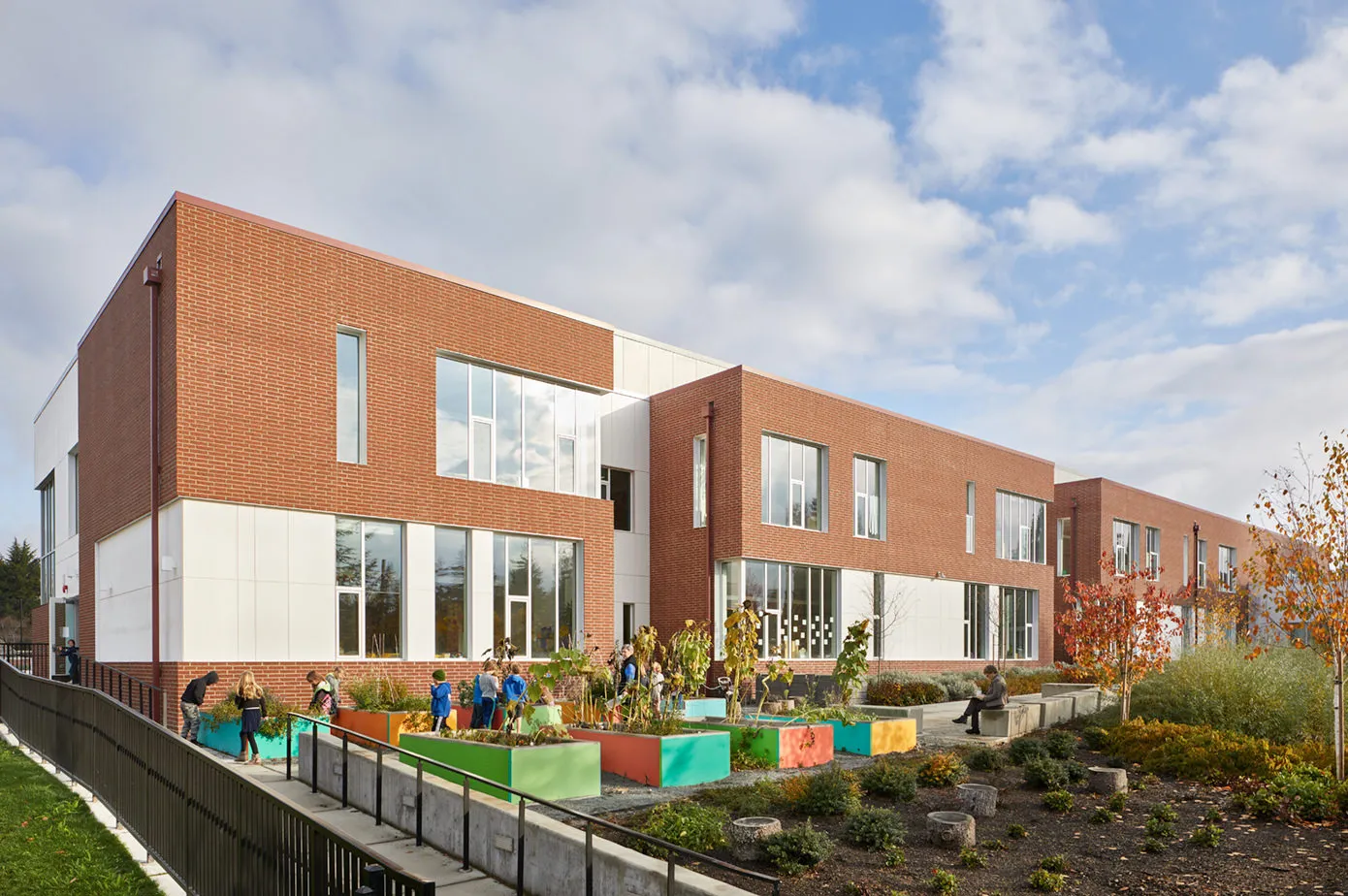 Photo taken from the Southwest featuring the outdoor garden with students surrounding the planters. Photo taken from the Southwest featuring the outdoor garden with students surrounding the planters.