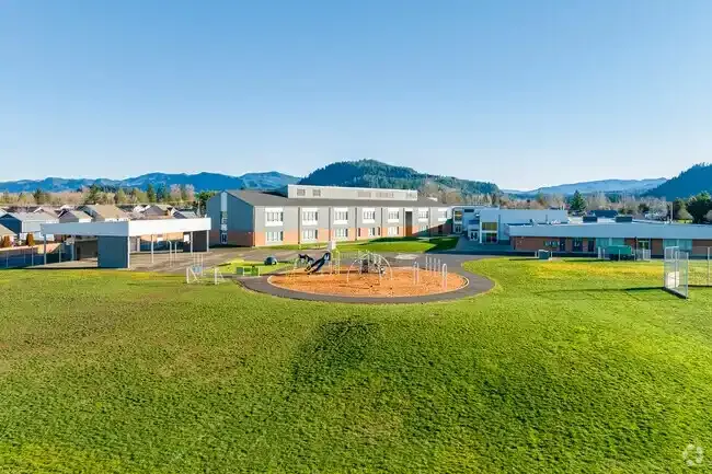 Photo of the new play structure with the school in the background. Photo of the new play structure with the school in the background.