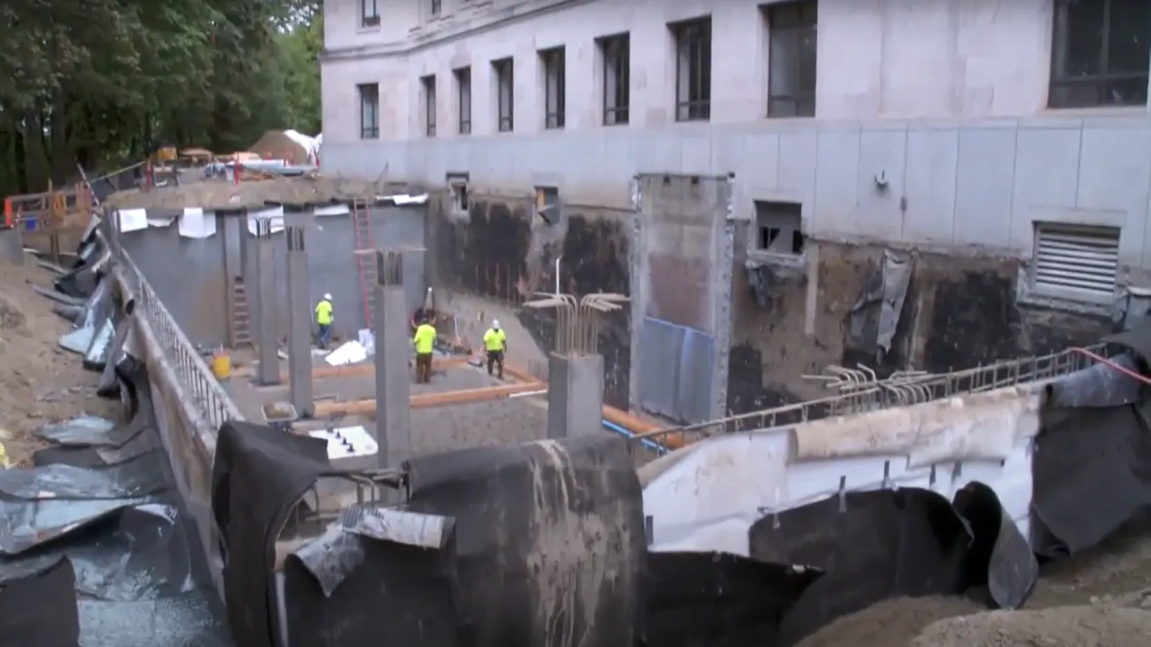Mass excavationi behind the John L O'Brien building with concrete columns and floor slab in place.