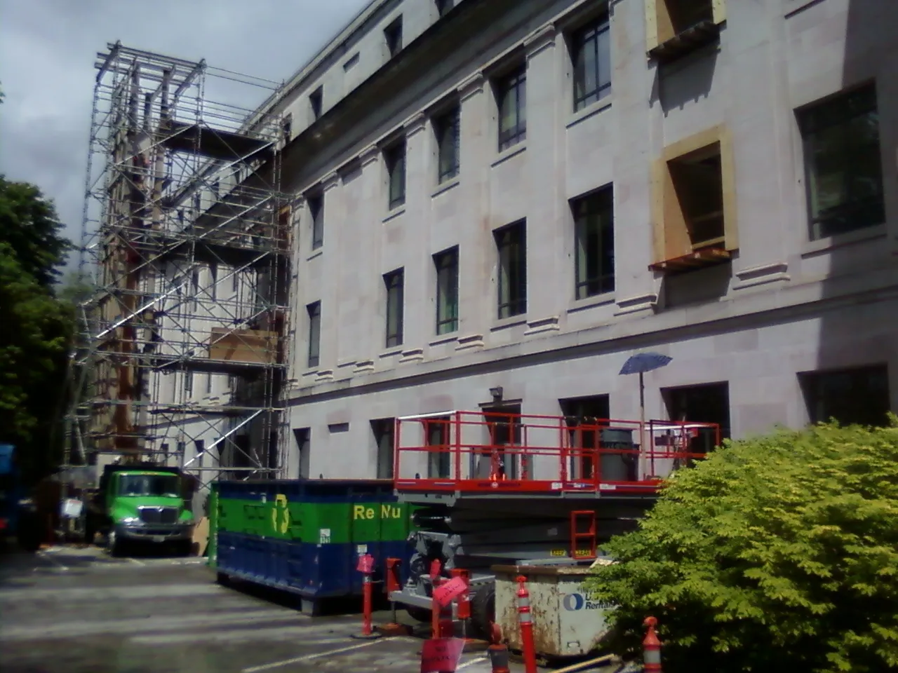 Photo of South-west side of building, after paving, with scaffolding erected to the top of the building.