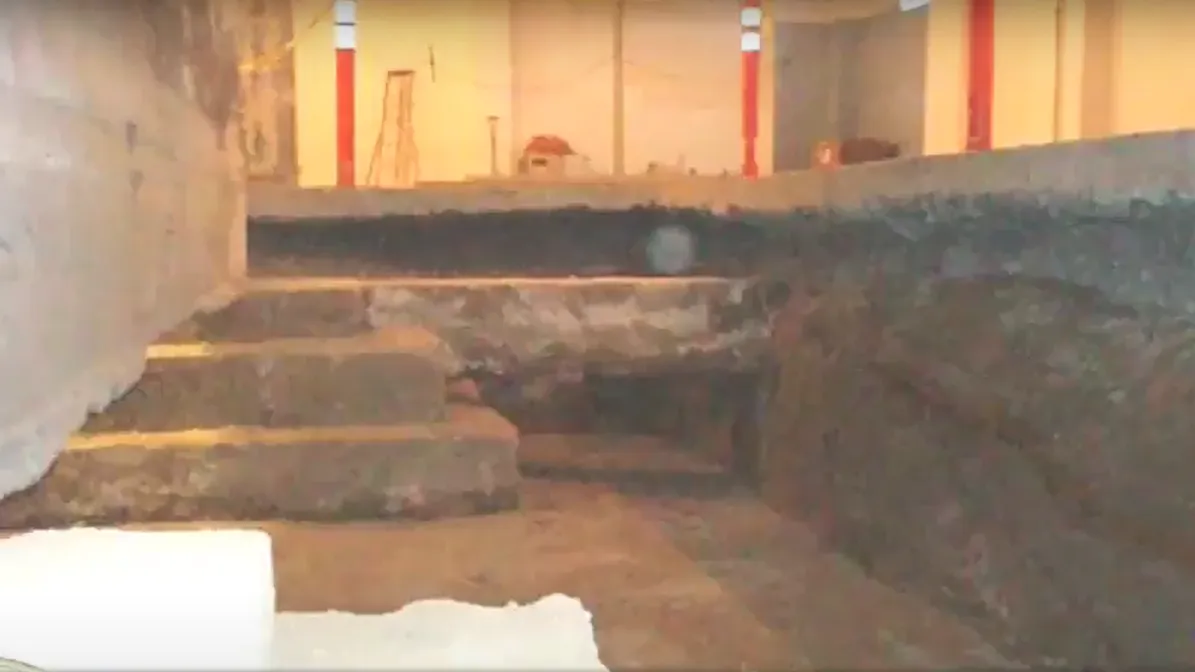 Photo of exposed concrete foundations, below floor level.